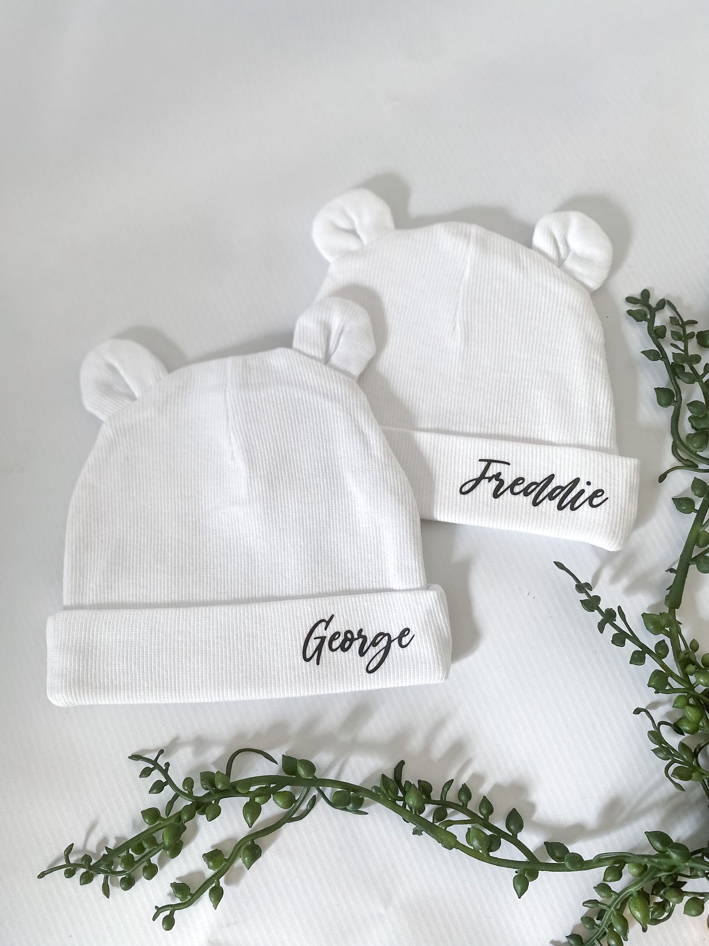 White baby hat with italic black name personalisation