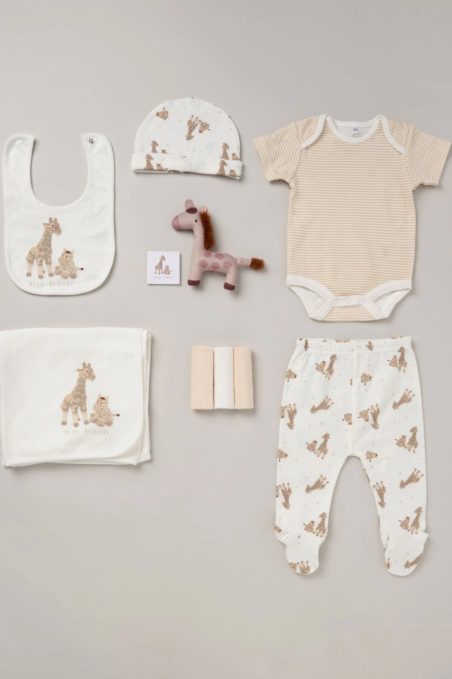 10 piece baby clothing gift set with toy, washcloths, bib, hat and blanket. Giraffe themed print in white and brown tones.