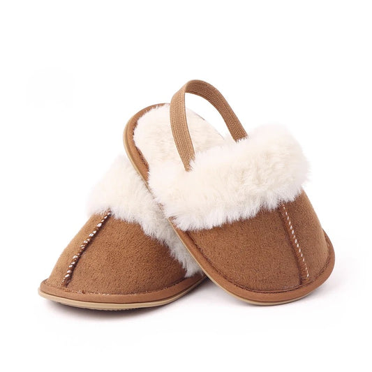 caramel brown fluffed baby slippers with elastic to hold baby's feet.