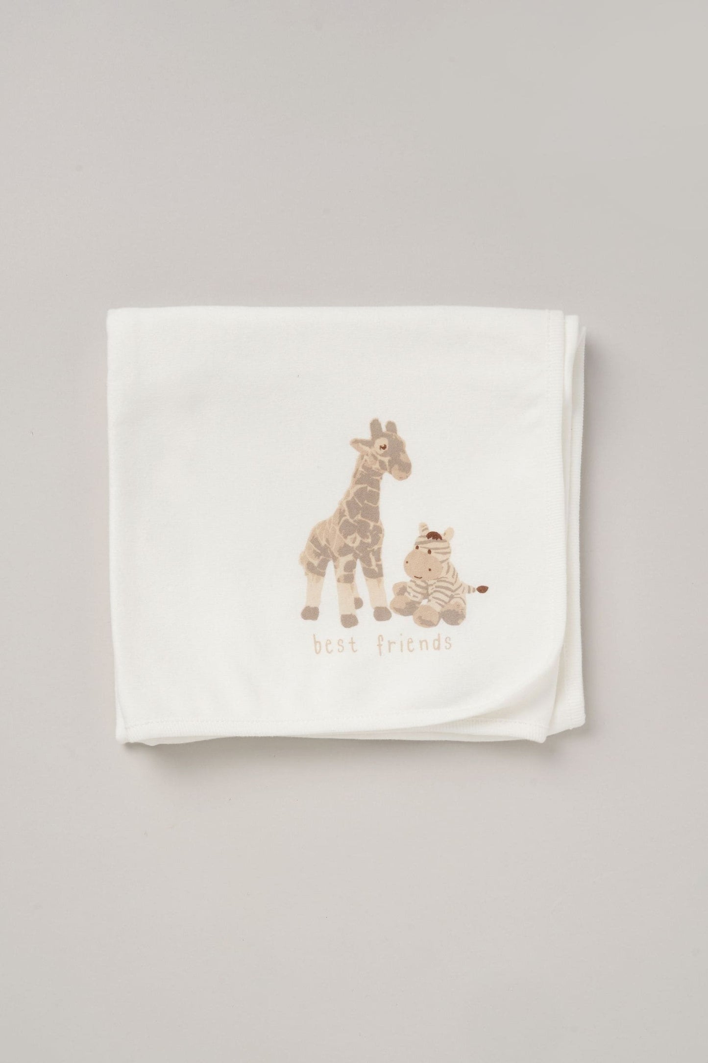 Baby cotton blanket in white with giraffe and zebra print called “best friends”. 