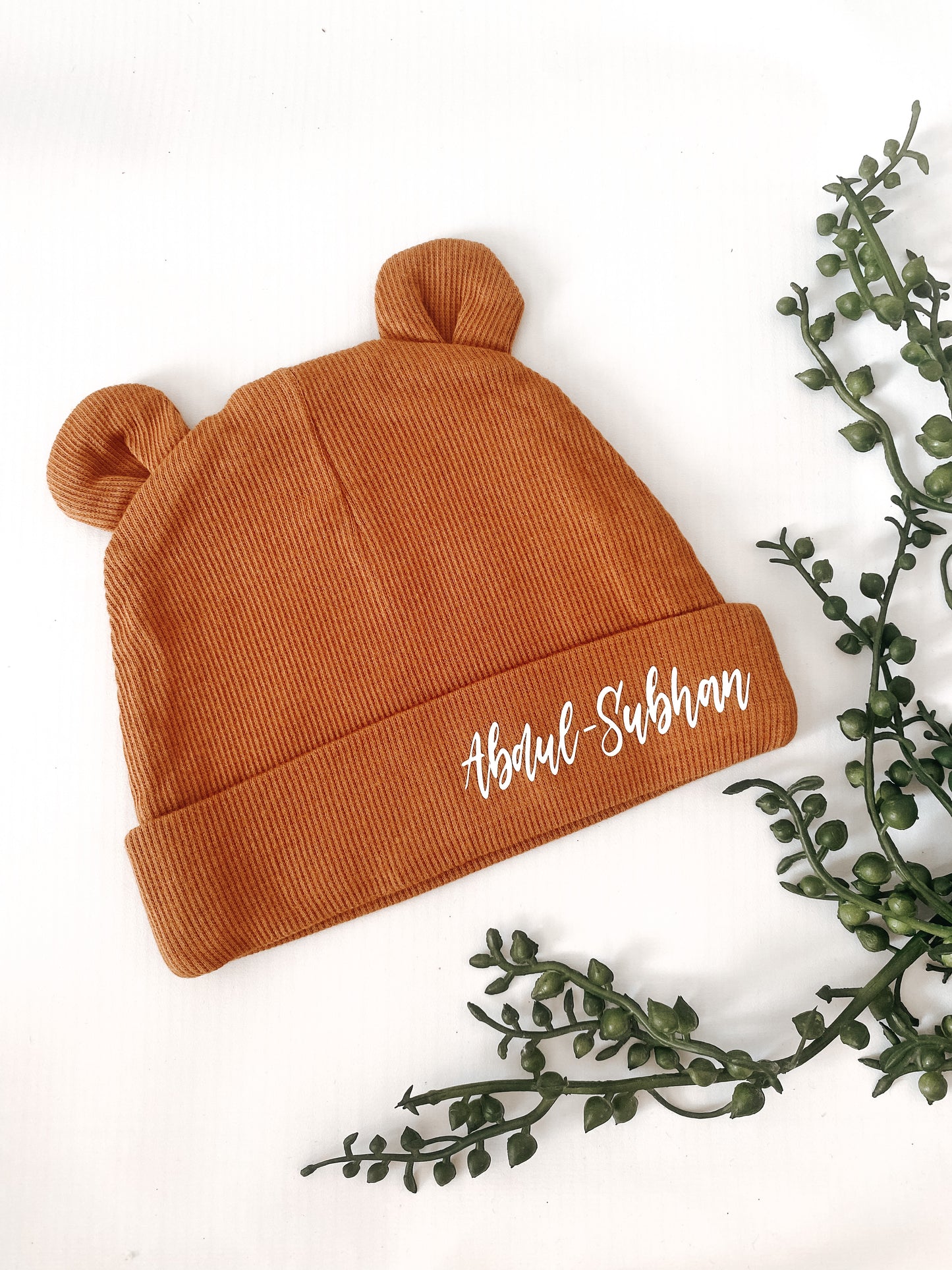 bear ears mustard baby hat in ribbed material. Name personalisation in white italic font.