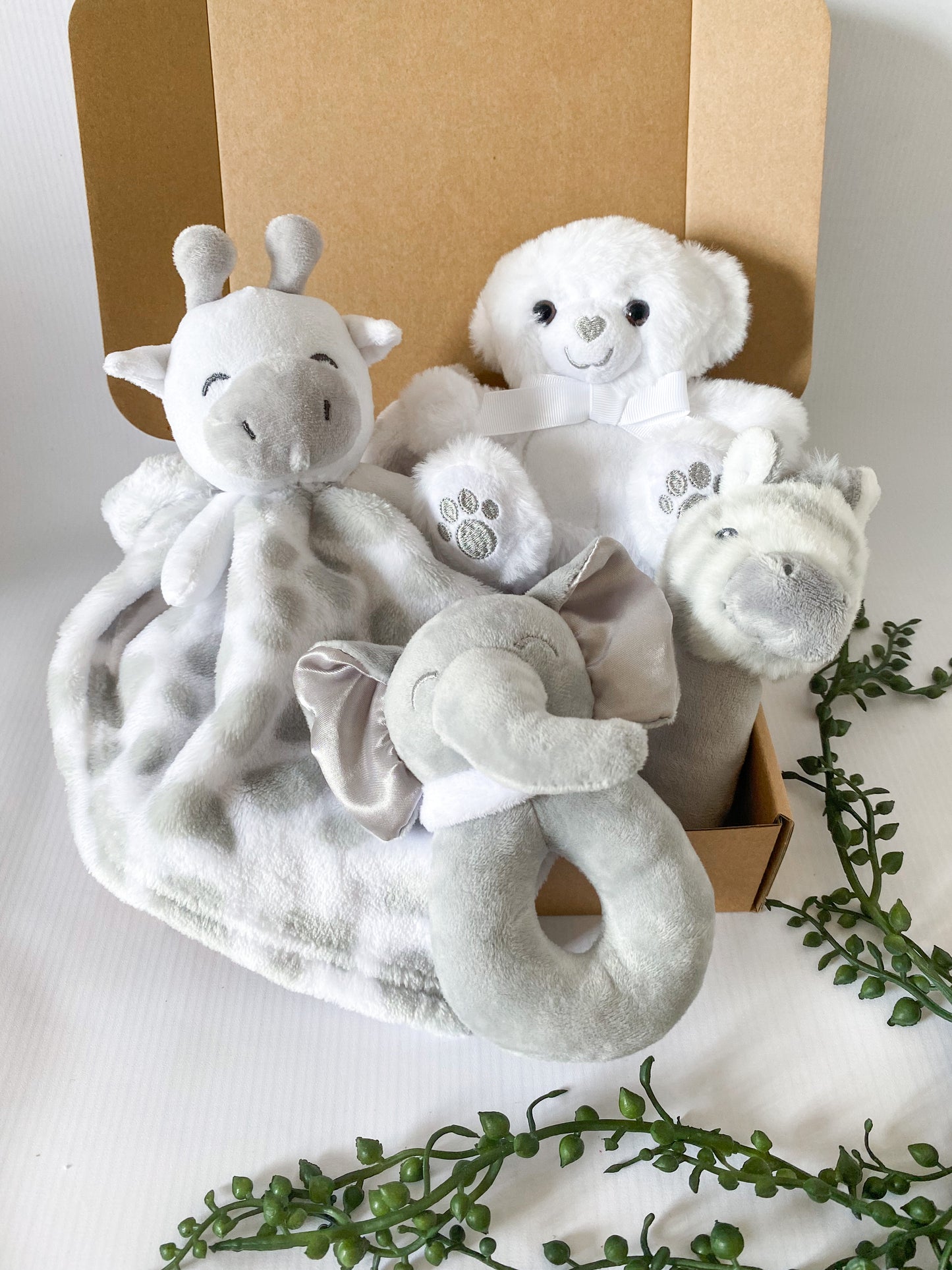 Grey and white gift box of safari animal toys including rattle stick, rattle ring, comforter and bear cuddle toy.