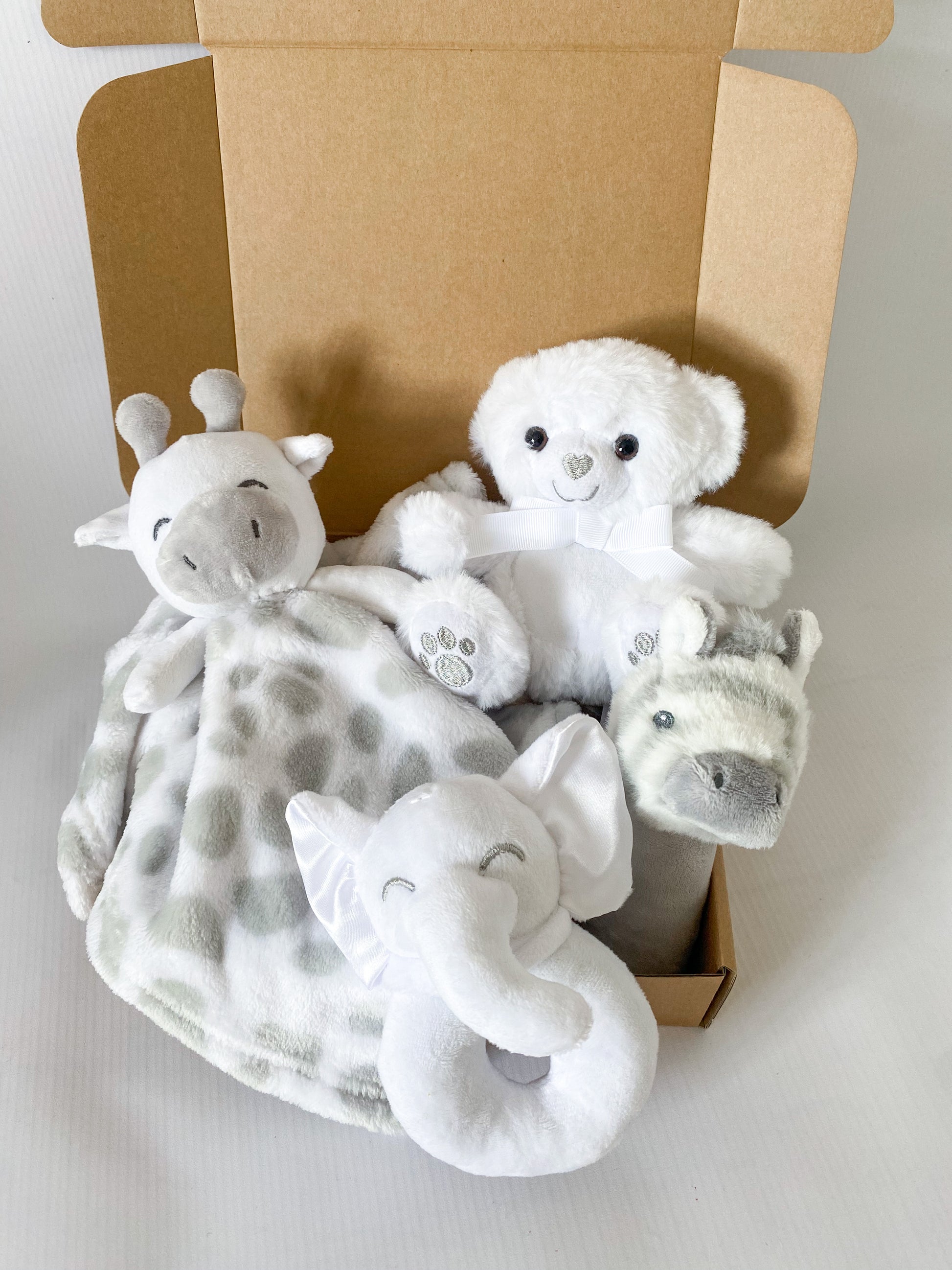 Grey and white gift box of safari animal toys including rattle stick, rattle ring, comforter and bear cuddle toy.