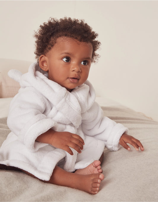 toddler wearing white bathrobe in seated position